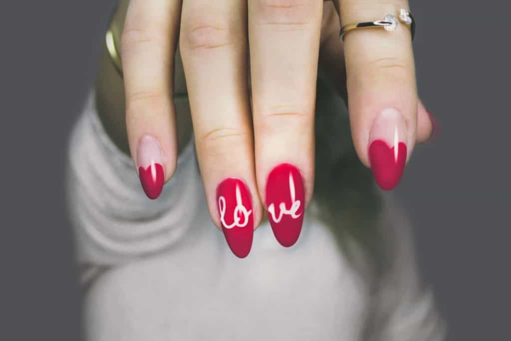 Photo by DESIGNECOLOGIST on Unsplash. Acrylic nails with red colour